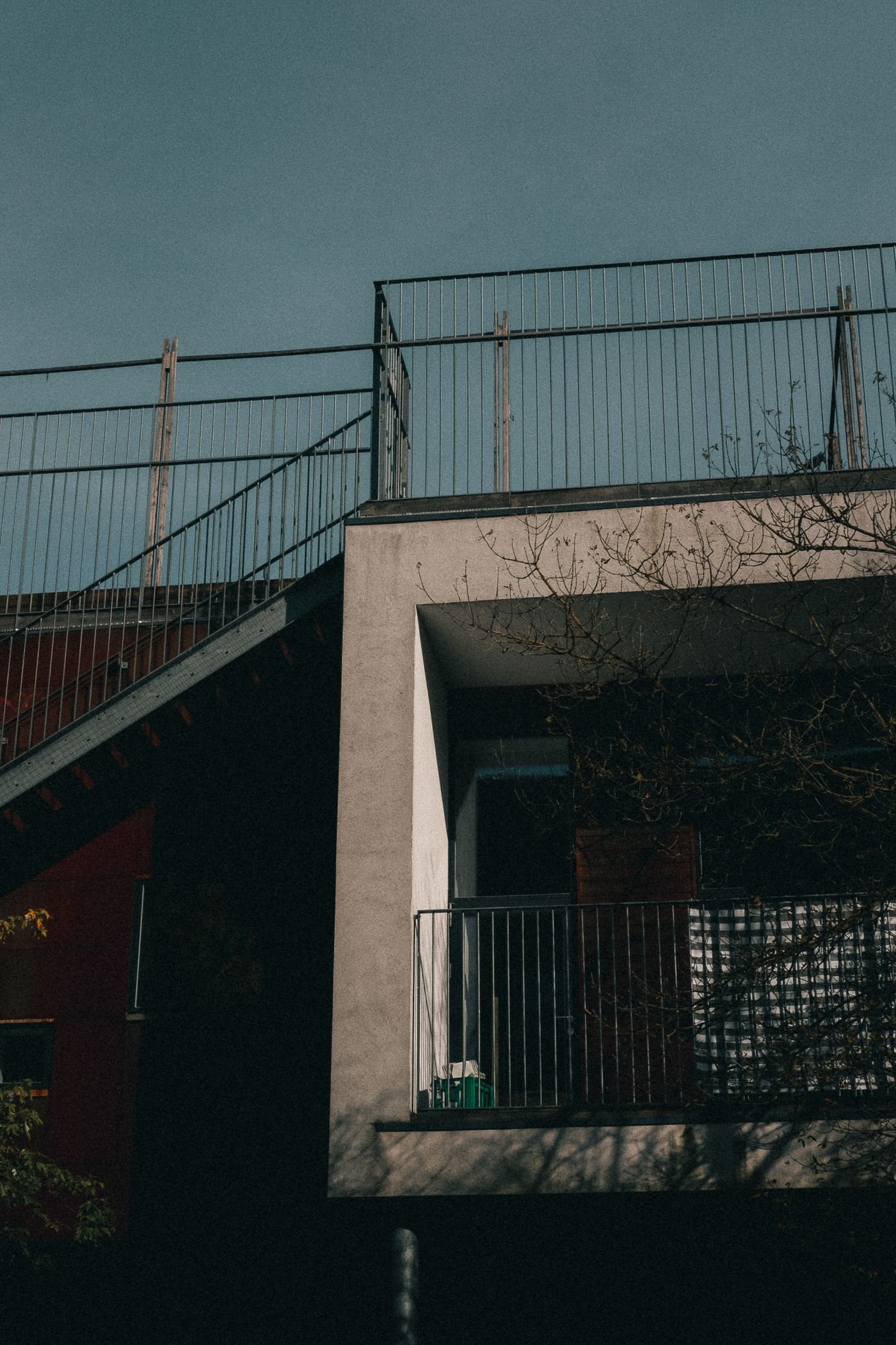 Modern Copenhagen building with a roof terrace and tree shadows