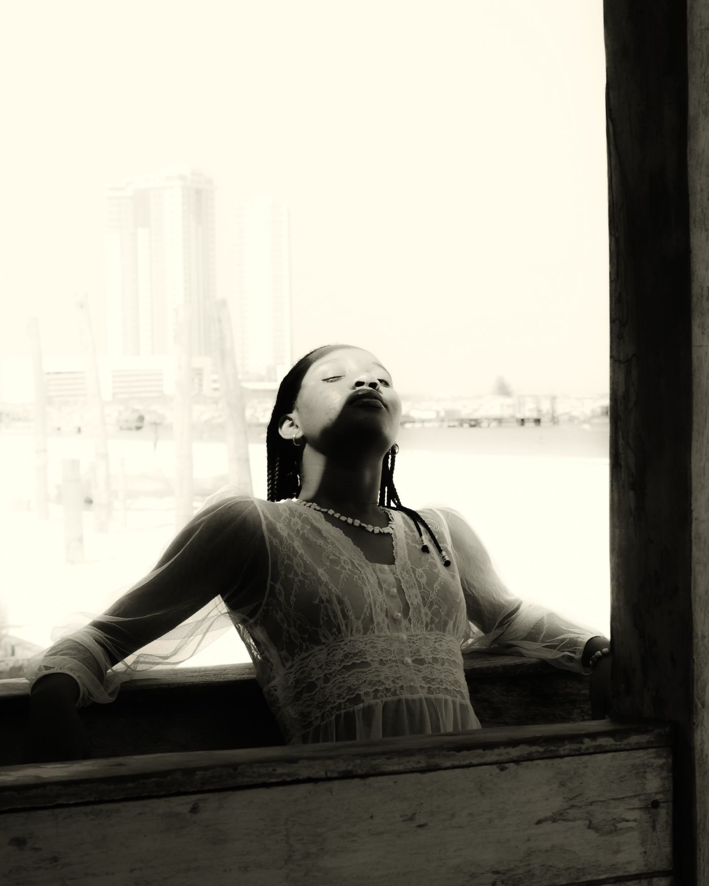 Black and white portrait of a woman resting in window light