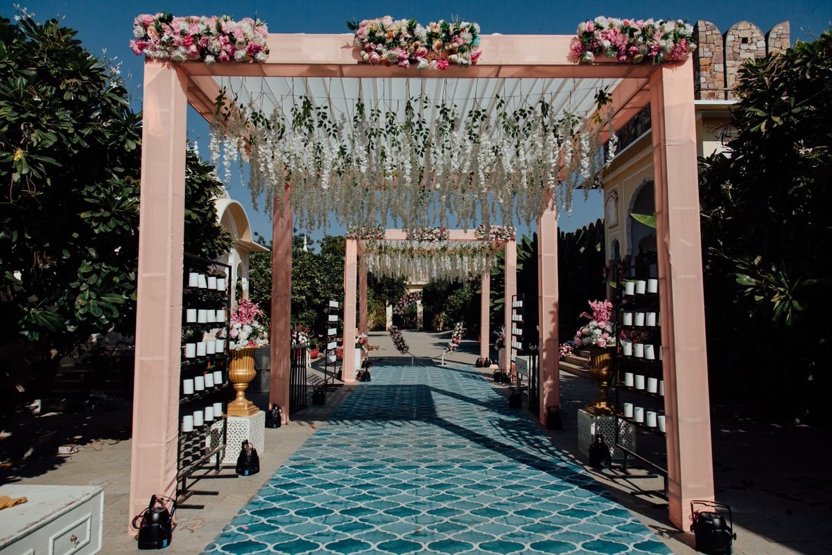 Open-air wedding ceremony aisle beneath flower-covered arches