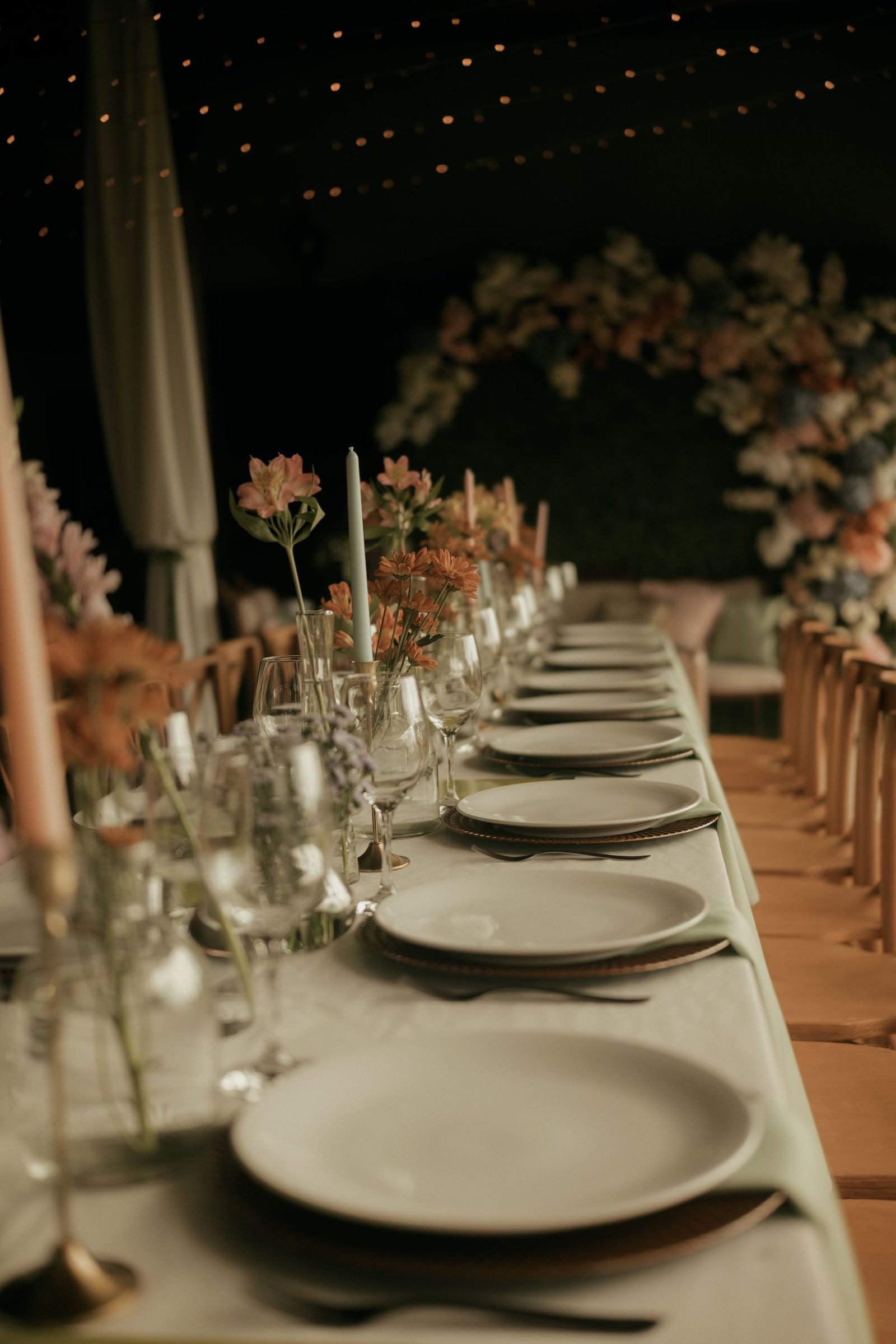 Candlelit wedding reception table set with flowers and glassware