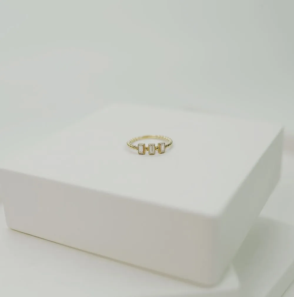 Lintel ring in gold on a white plinth