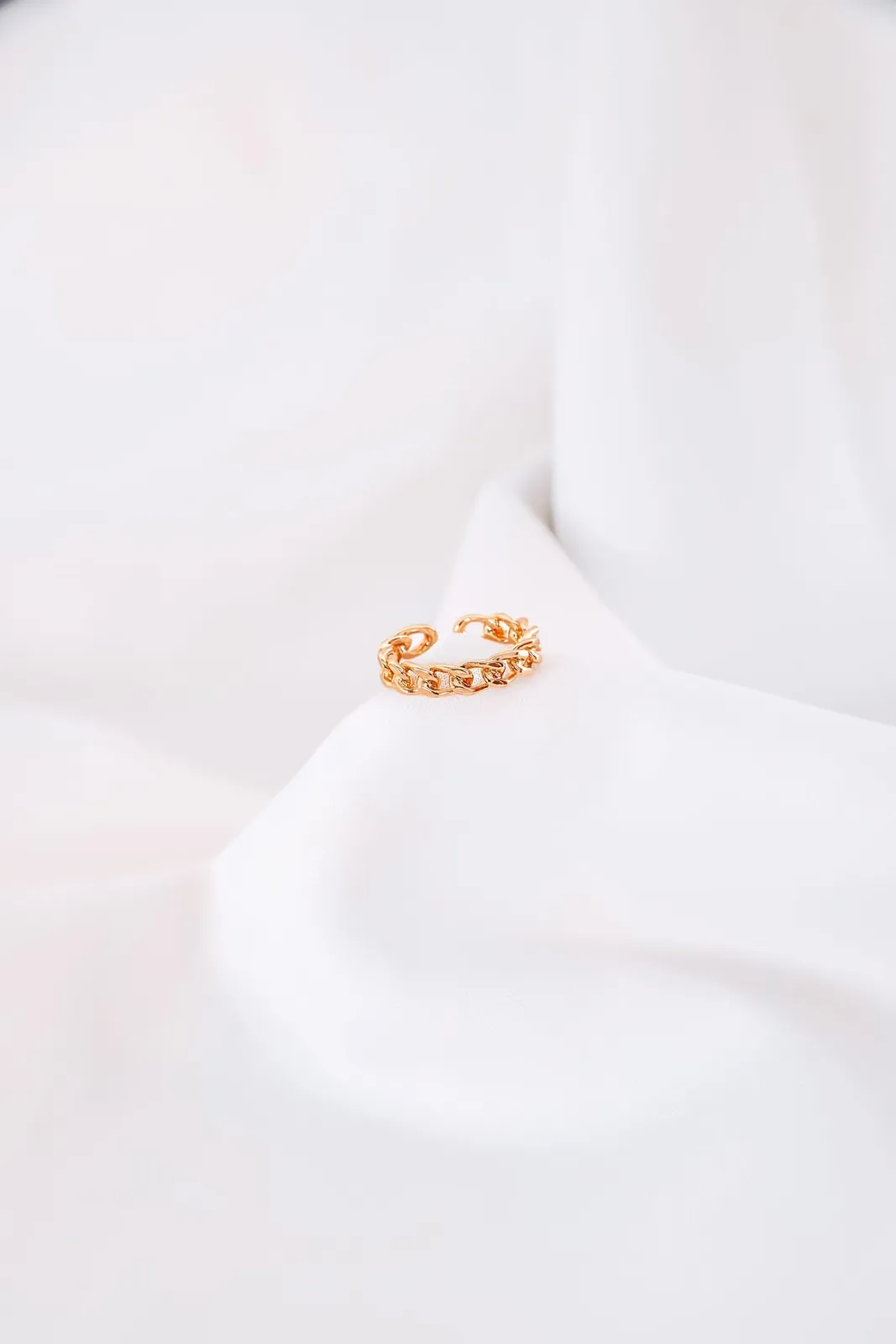 Solstice chain ring in rose gold resting on white silk