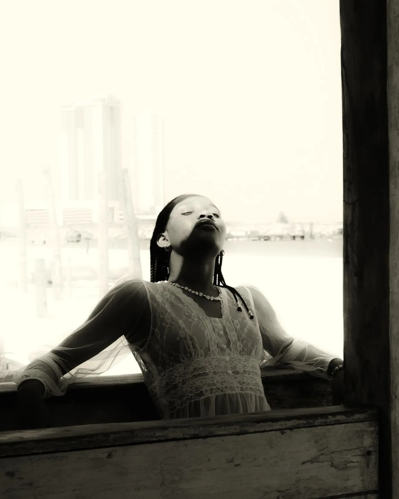 Black and white portrait of a woman resting in window light